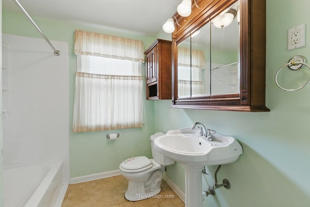 full bath with healthy amount of natural light, toilet, baseboards, and tile patterned floors