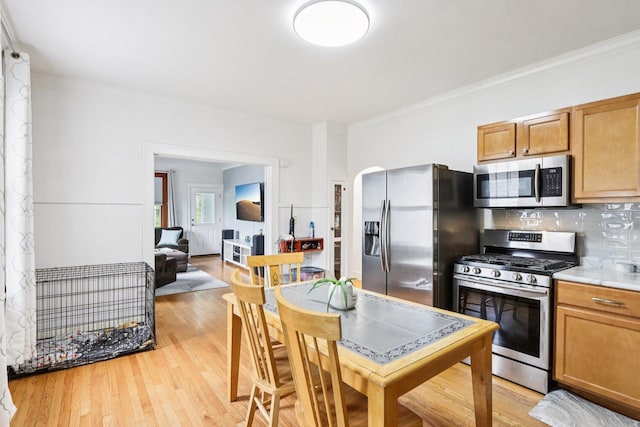38 Highview Ave, Fox Lake, IL 60020 - kitchen featuring appliances with stainless steel finishes, ornamental molding, backsplash, light wood-type flooring, and light countertops