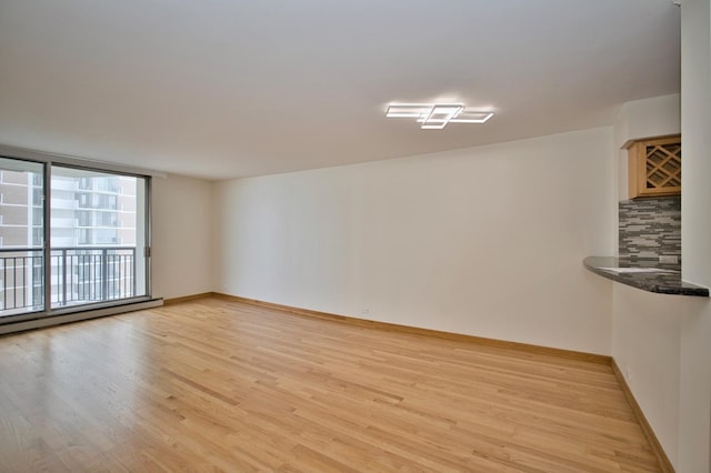 6007 N Sheridan Rd Unit 25F, Chicago, IL 60660 - unfurnished room with light wood-type flooring, baseboards, and a baseboard radiator
