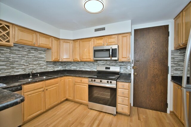 6007 N Sheridan Rd Unit 25F, Chicago, IL 60660 - kitchen with stainless steel appliances, a sink, light wood finished floors, and decorative backsplash