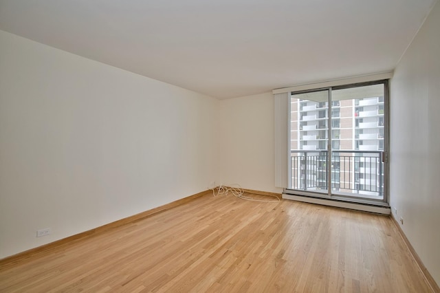 6007 N Sheridan Rd Unit 25F, Chicago, IL 60660 - empty room with a baseboard heating unit and light wood-style floors