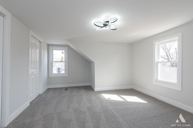 bonus room with carpet floors, plenty of natural light, and baseboards