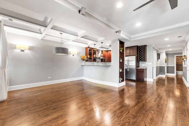 unfurnished living room featuring ceiling fan, baseboards, dark wood finished floors, ornamental molding, and beam ceiling