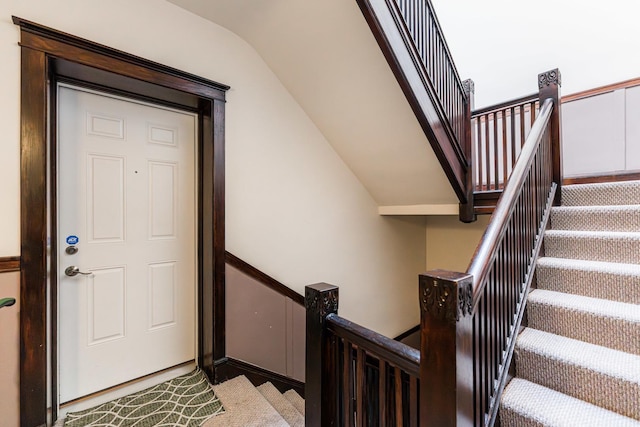 stairs featuring lofted ceiling and carpet flooring