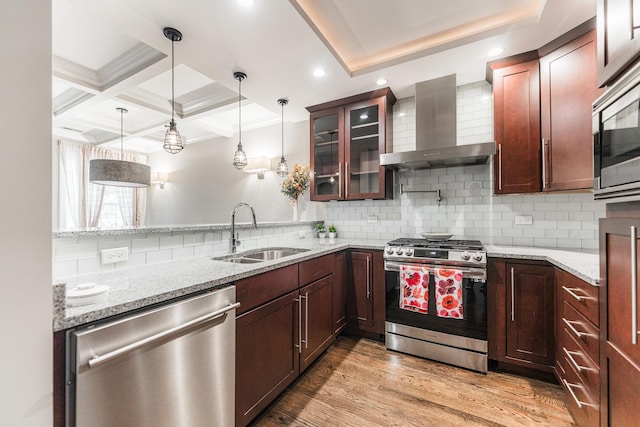 6337 N Magnolia Ave Unit 2, Chicago, IL 60660 - kitchen featuring appliances with stainless steel finishes, wall chimney exhaust hood, glass insert cabinets, light wood-style floors, and hanging light fixtures