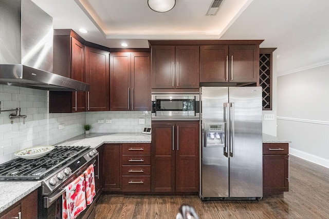 6337 N Magnolia Ave Unit 2, Chicago, IL 60660 - kitchen featuring appliances with stainless steel finishes, wall chimney range hood, dark wood finished floors, tasteful backsplash, and light stone counters