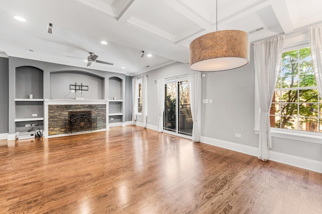 unfurnished living room featuring crown molding, plenty of natural light, baseboards, recessed lighting, and built in shelves