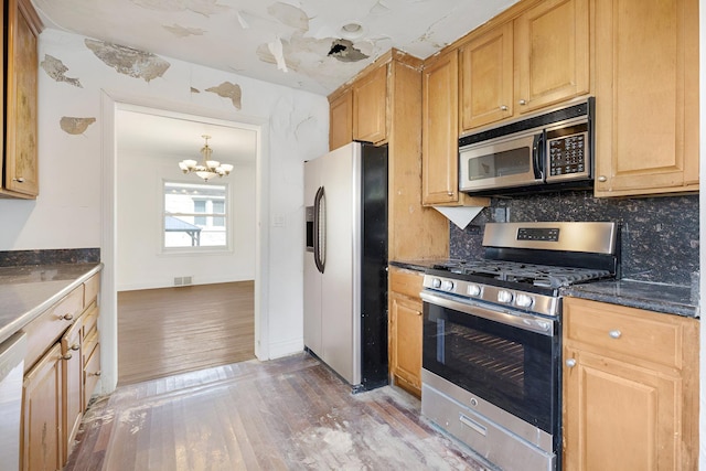 7810 Kildare Ave, Skokie, IL 60076 - kitchen featuring stainless steel appliances, light wood finished floors, a chandelier, and tasteful backsplash