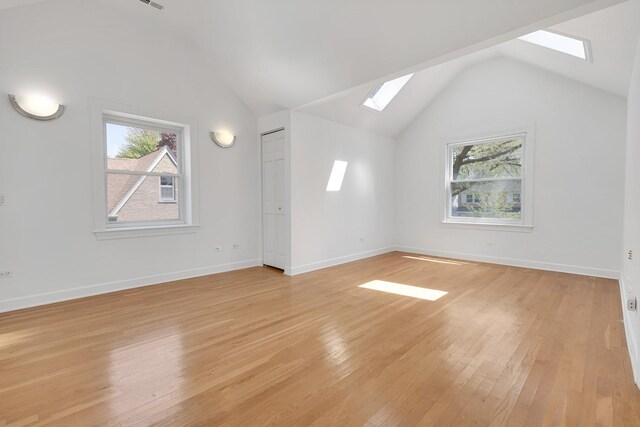 7810 Kildare Ave, Skokie, IL 60076 - additional living space with a skylight, vaulted ceiling, plenty of natural light, light wood-style floors, and baseboards
