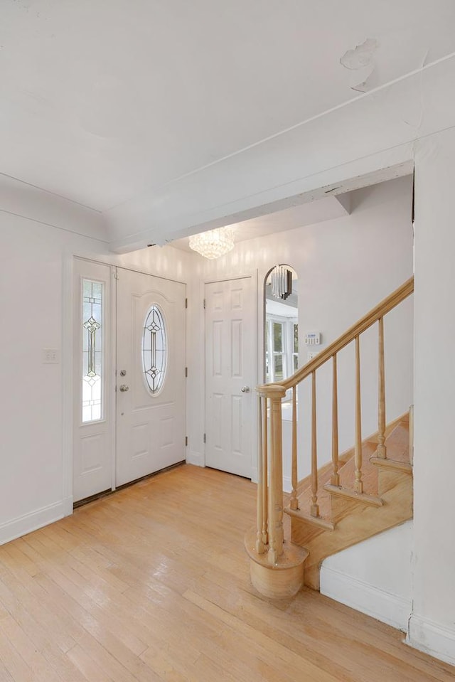 7810 Kildare Ave, Skokie, IL 60076 - foyer entrance with light wood-style floors, a chandelier, stairs, and baseboards
