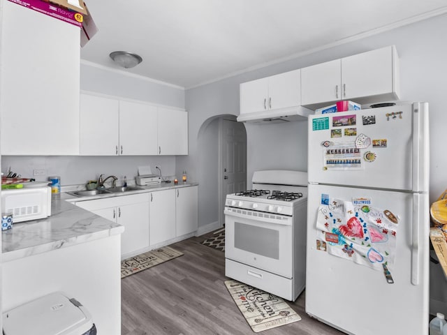 112 Webb St, Calumet City, IL 60409 - kitchen with white appliances, a sink, under cabinet range hood, arched walkways, and light countertops