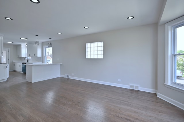 3001 N Neenah Ave, Chicago, IL 60634 - unfurnished living room with plenty of natural light, wood finished floors, baseboards, recessed lighting, and a sink