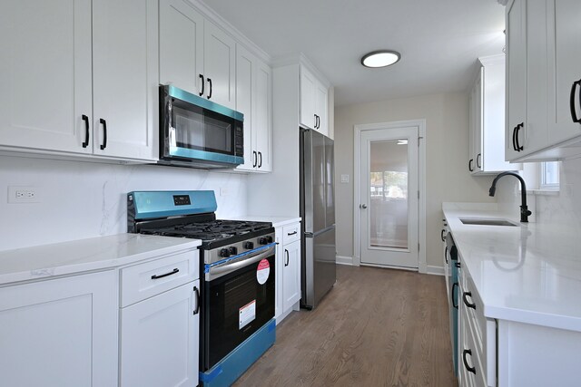 3001 N Neenah Ave, Chicago, IL 60634 - kitchen featuring stainless steel appliances, a sink, wood finished floors, white cabinets, and light stone countertops
