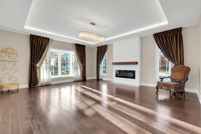 471 Stagecoach, Glen Ellyn, IL 60137 - living room featuring a tray ceiling, wood finished floors, a glass covered fireplace, and baseboards