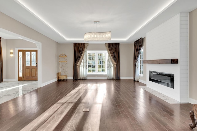 471 Stagecoach, Glen Ellyn, IL 60137 - unfurnished living room featuring a raised ceiling, a large fireplace, baseboards, and wood finished floors