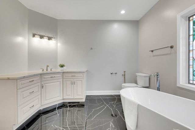 471 Stagecoach, Glen Ellyn, IL 60137 - bathroom with marble tiled floors, a freestanding tub, toilet, vanity, and baseboards