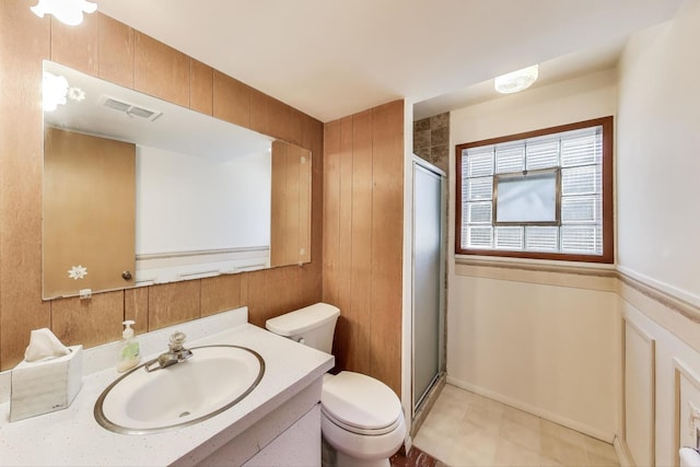 full bathroom featuring a stall shower, toilet, and vanity
