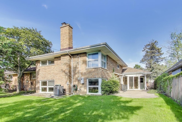 back of property featuring a chimney, cooling unit, brick siding, and a patio area