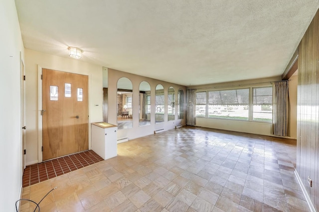 foyer entrance featuring a baseboard heating unit, baseboards, and a textured ceiling