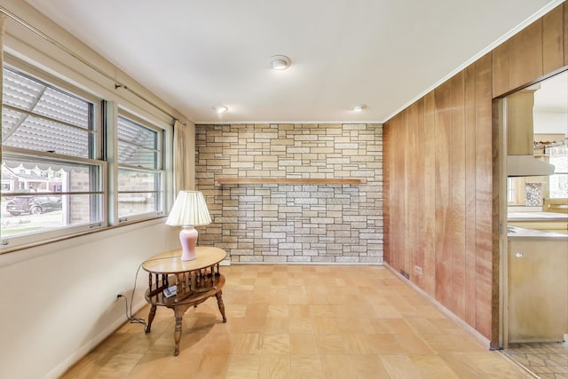 sitting room with wood walls, baseboards, and light floors
