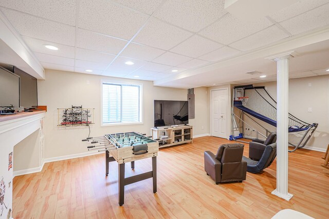 10941 Preston Pkwy, Huntley, IL 60142 - recreation room featuring decorative columns, a paneled ceiling, baseboards, and light wood-style flooring