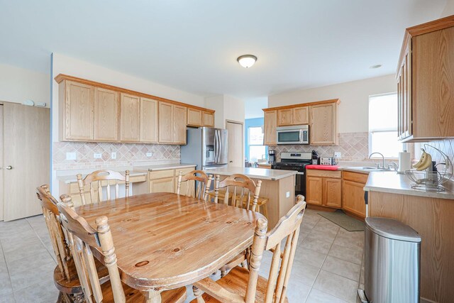 10941 Preston Pkwy, Huntley, IL 60142 - kitchen featuring appliances with stainless steel finishes, light brown cabinets, tasteful backsplash, a sink, and light tile patterned flooring