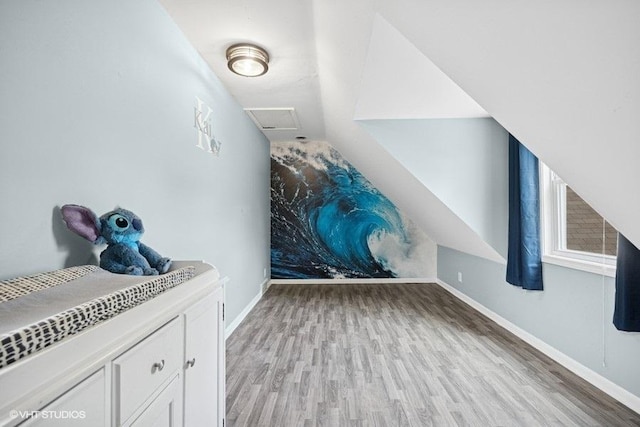 bonus room with light wood finished floors, baseboards, and lofted ceiling
