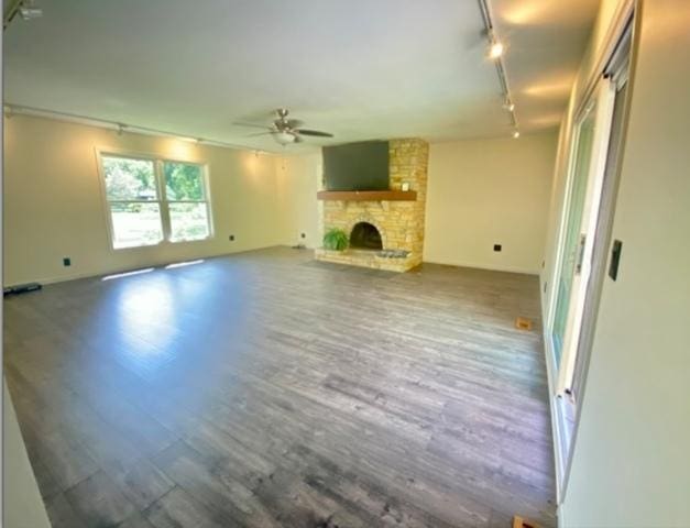 4775 Douglas Rd, Oswego, IL 60543 - unfurnished living room featuring track lighting, a ceiling fan, wood finished floors, and a stone fireplace