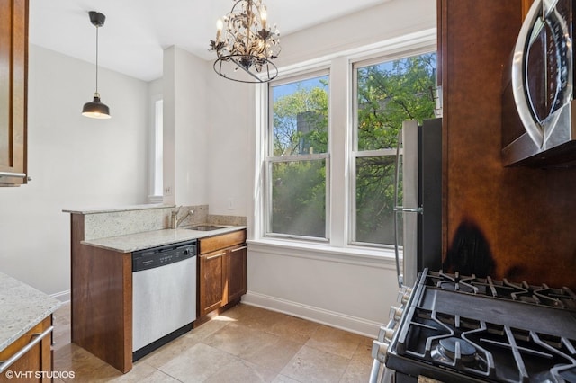 2328 N Oakley Ave Unit 2E, Chicago, IL 60647 - kitchen featuring stainless steel appliances, a sink, brown cabinetry, a chandelier, and light stone counters