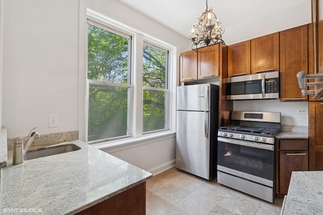 2328 N Oakley Ave Unit 2E, Chicago, IL 60647 - kitchen with stainless steel appliances, a sink, a chandelier, and light stone countertops