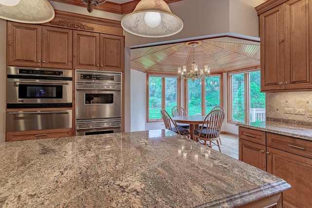 25410 N Cayuga Trl, Lake Barrington, IL 60010 - kitchen featuring a warming drawer, stainless steel double oven, a chandelier, decorative backsplash, and stone counters