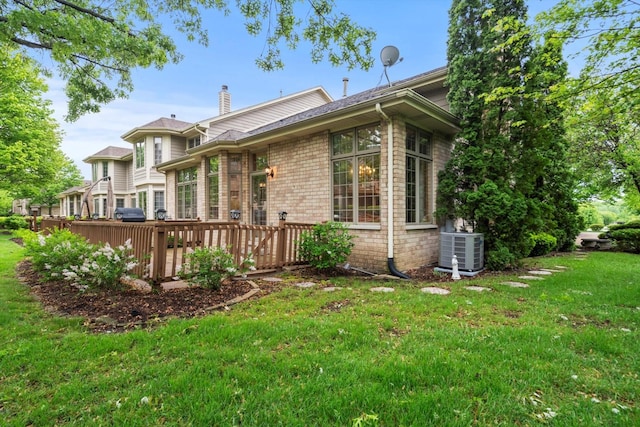 16 Pine Needles Dr, Lemont, IL 60439 - back of property with central air condition unit, a lawn, a chimney, a wooden deck, and brick siding
