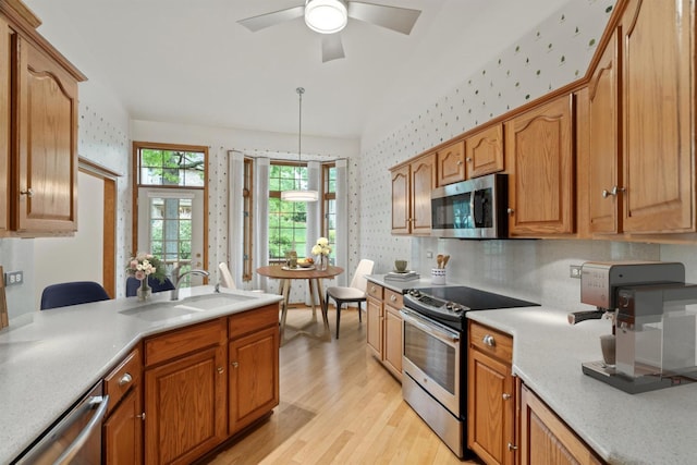 16 Pine Needles Dr, Lemont, IL 60439 - kitchen featuring appliances with stainless steel finishes, wallpapered walls, a sink, light wood-style floors, and light countertops
