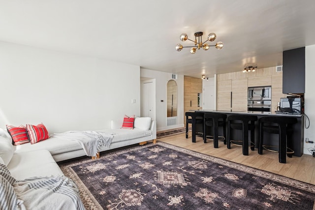 6301 N Sheridan Rd Unit 17J, Chicago, IL 60660 - living area with arched walkways, a chandelier, and light wood finished floors