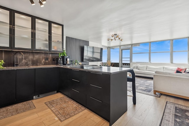 6301 N Sheridan Rd Unit 17J, Chicago, IL 60660 - kitchen featuring dark cabinets, modern cabinets, open floor plan, a sink, and a breakfast bar area