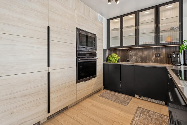 6301 N Sheridan Rd Unit 17J, Chicago, IL 60660 - kitchen with oven, a sink, built in microwave, dark cabinets, and glass insert cabinets