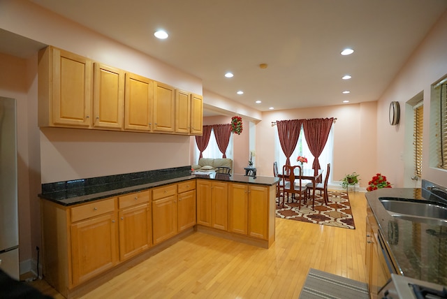 4310 Church St, Skokie, IL 60076 - kitchen featuring light wood-style flooring, a sink, a peninsula, recessed lighting, and dark stone countertops