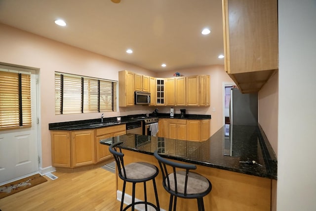 4310 Church St, Skokie, IL 60076 - kitchen with stainless steel appliances, a sink, light brown cabinetry, light wood-style floors, and a peninsula