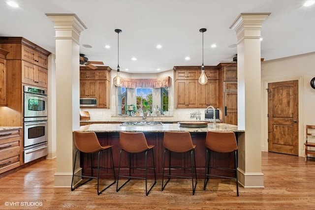 41W590 Bowgren Dr, Campton Hills, IL 60119 - kitchen with ornate columns, stainless steel appliances, a warming drawer, light stone counters, and recessed lighting
