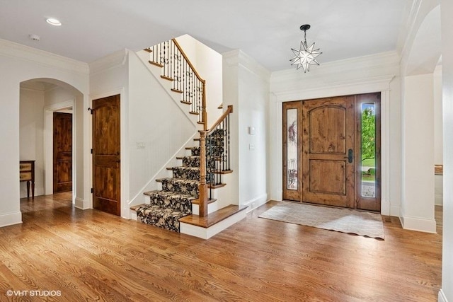 41W590 Bowgren Dr, Campton Hills, IL 60119 - entryway with arched walkways, wood finished floors, stairs, ornamental molding, and baseboards