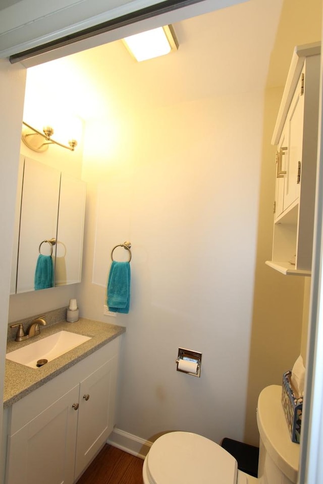 1188 Cypress Ln, Elk Grove Village, IL 60007 - bathroom featuring toilet, vanity, wood finished floors, and baseboards