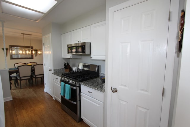1188 Cypress Ln, Elk Grove Village, IL 60007 - kitchen featuring appliances with stainless steel finishes, white cabinets, dark wood-type flooring, dark stone counters, and decorative light fixtures
