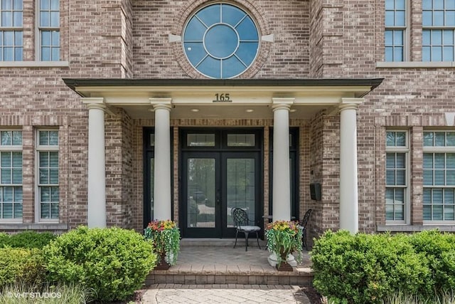 doorway to property featuring french doors and brick siding