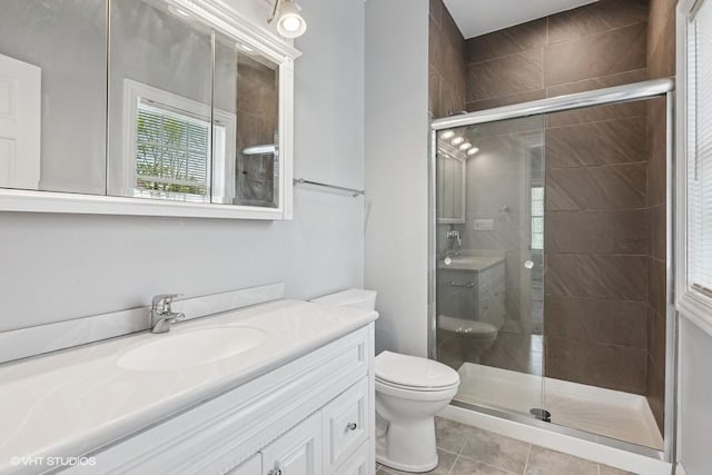 full bath with a shower stall, toilet, vanity, and tile patterned floors