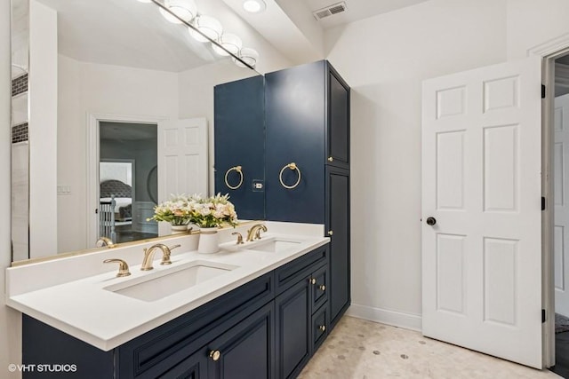 bathroom with double vanity and baseboards