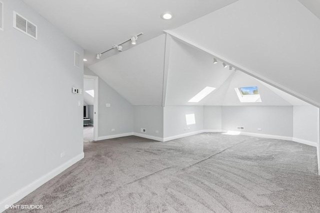 bonus room with a skylight, vaulted ceiling, carpet floors, baseboards, and recessed lighting