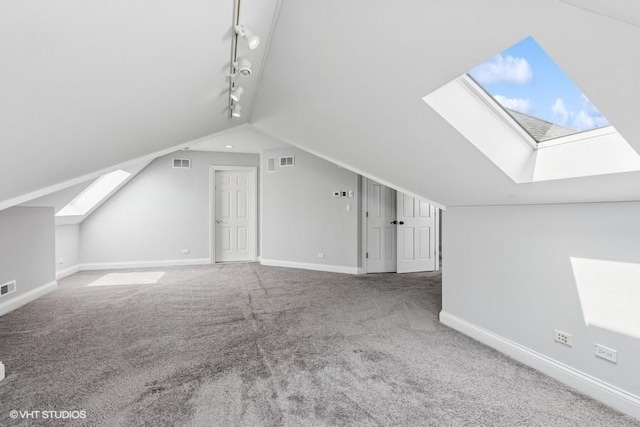 additional living space with a skylight, carpet floors, baseboards, and vaulted ceiling