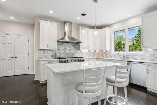 kitchen featuring wall chimney exhaust hood, stainless steel dishwasher, a sink, range, and light countertops