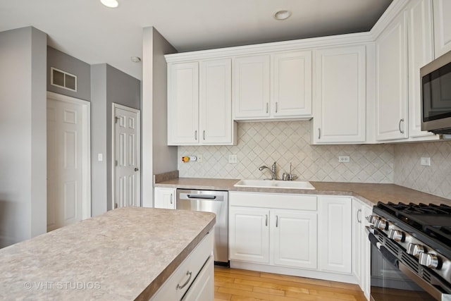 1119 Orangery Ct, Carol Stream, IL 60188 - kitchen featuring appliances with stainless steel finishes, white cabinetry, light countertops, backsplash, and recessed lighting