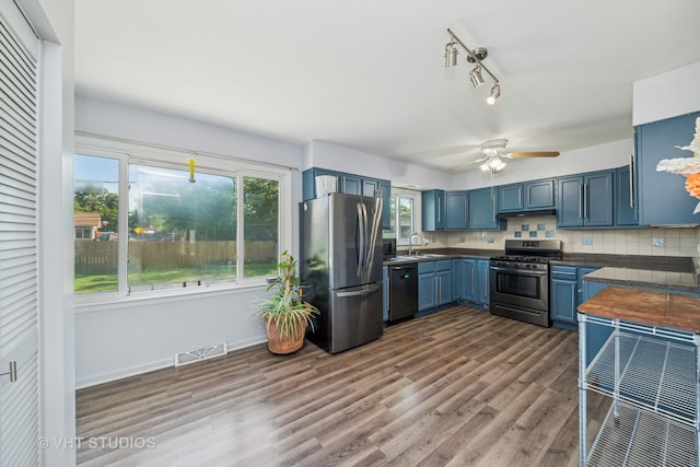 1826 E Tano Ln, Mount Prospect, IL 60056 - kitchen featuring appliances with stainless steel finishes, blue cabinetry, dark wood-style flooring, under cabinet range hood, and ceiling fan